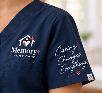 Memory+ Home Care’s navy caregiver uniform and heart-and-home emblem